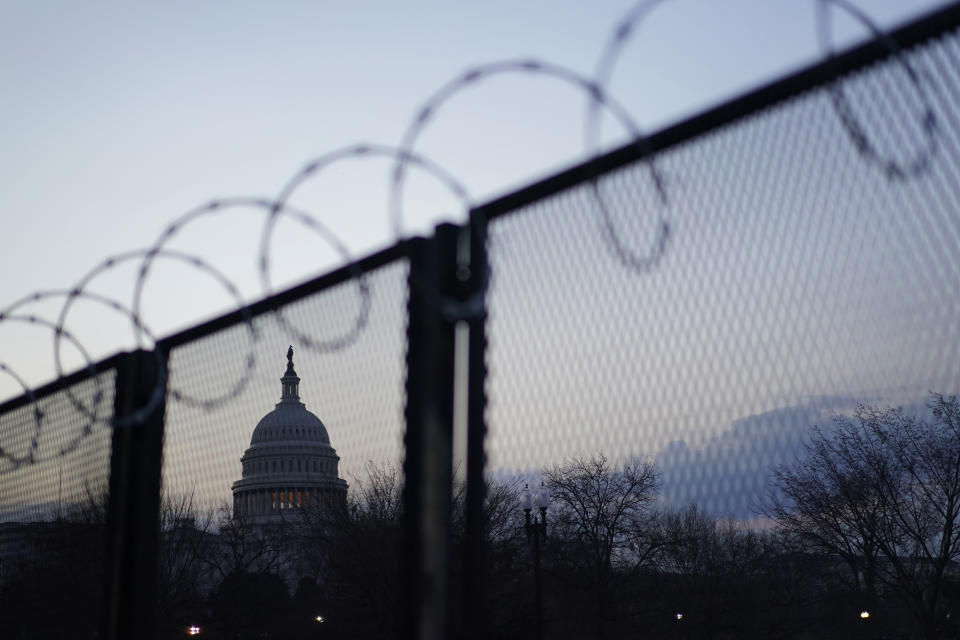 The Capitol dome is seen beyond a perimeter security fence topped with razor wire in Washington, early Thursday, March 4, 2021. (AP Photo/Carolyn Kaster)