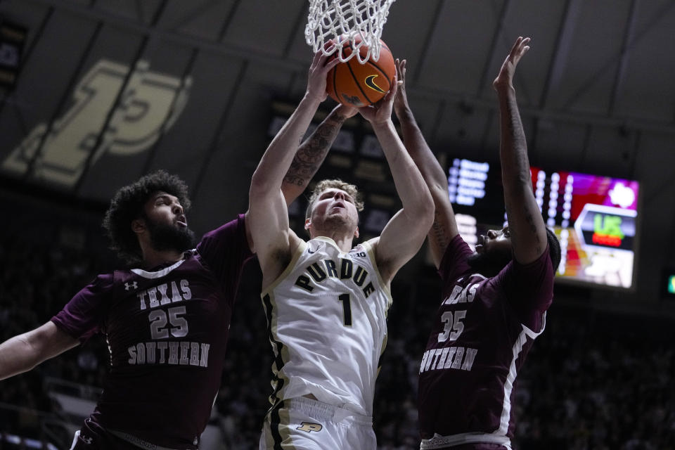 Purdue forward Caleb Furst (1) is fouled as he shoots between Texas Southern forward Grayson Carter (25) and forward Xavier Ball (35) during the second half of an NCAA college basketball game in West Lafayette, Ind., Tuesday, Nov. 28, 2023. (AP Photo/Michael Conroy)