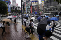 Morning commuters with umbrella cover a crosswalk Tuesday, July 27, 2021, in Tokyo. The rains have come to Tokyo and its Olympics. After many days of blistering sunshine, the rain cooled Tokyo by about 10 degrees and took the edge off. But worries about the effect of Tropical Storm Nepartak have led to changes in events and some cancellations of practices as preparations proceed. The storm is expected to make landfall in Japan on Tuesday evening. (AP Photo/Kiichiro Sato)