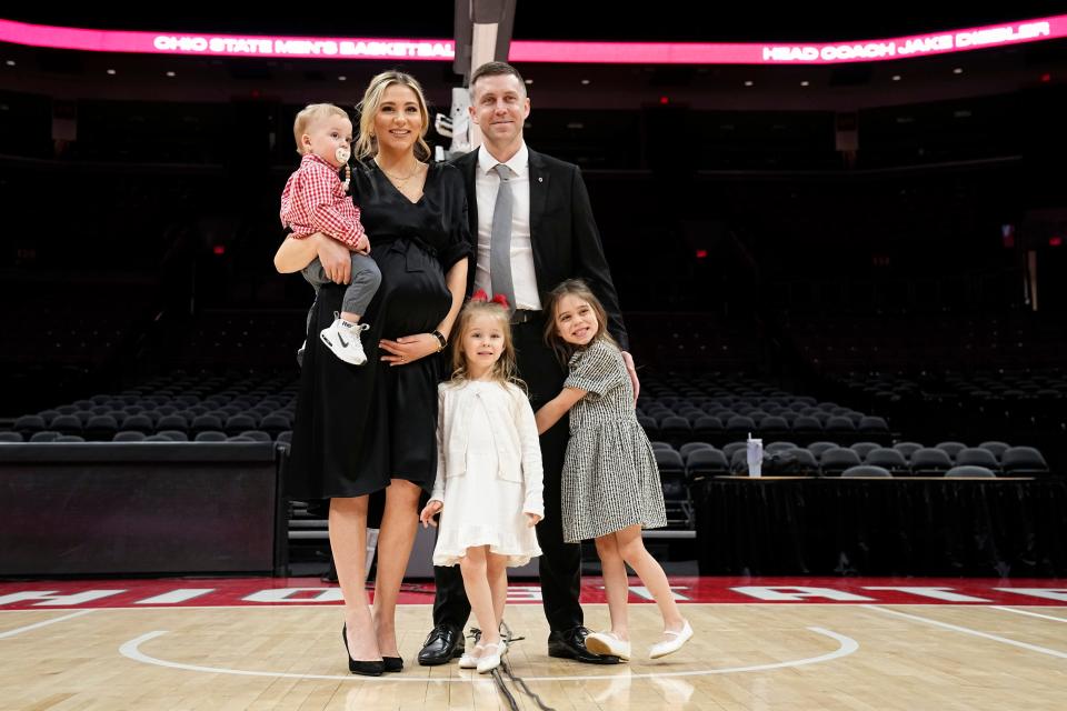 Mar 18, 2024; Columbus, OH, USA; Ohio State basketball head coach Jake Diebler stands with his wife, Jordan, son, Jax, and daughters, Jessa and Jaymes for a family photo during his introductory press conference at Value City Arena.