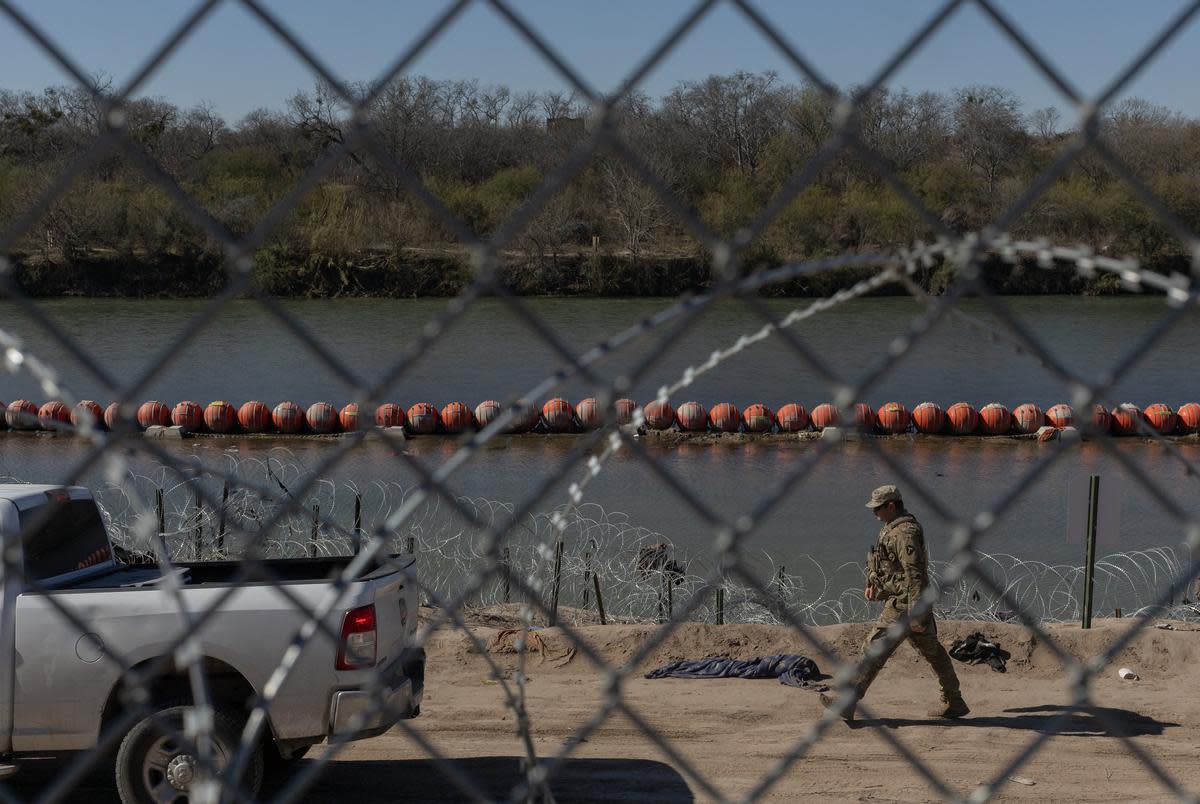 A Texas National Guard member walks past a line of buoys in Eagle Pass on Jan. 17, 2024. The U.S. Department of Justice, in a filing to the U.S. Supreme Court, stated that U.S. Border Patrol agents have been blocked off of a section of the border, accessible through Shelby Park.