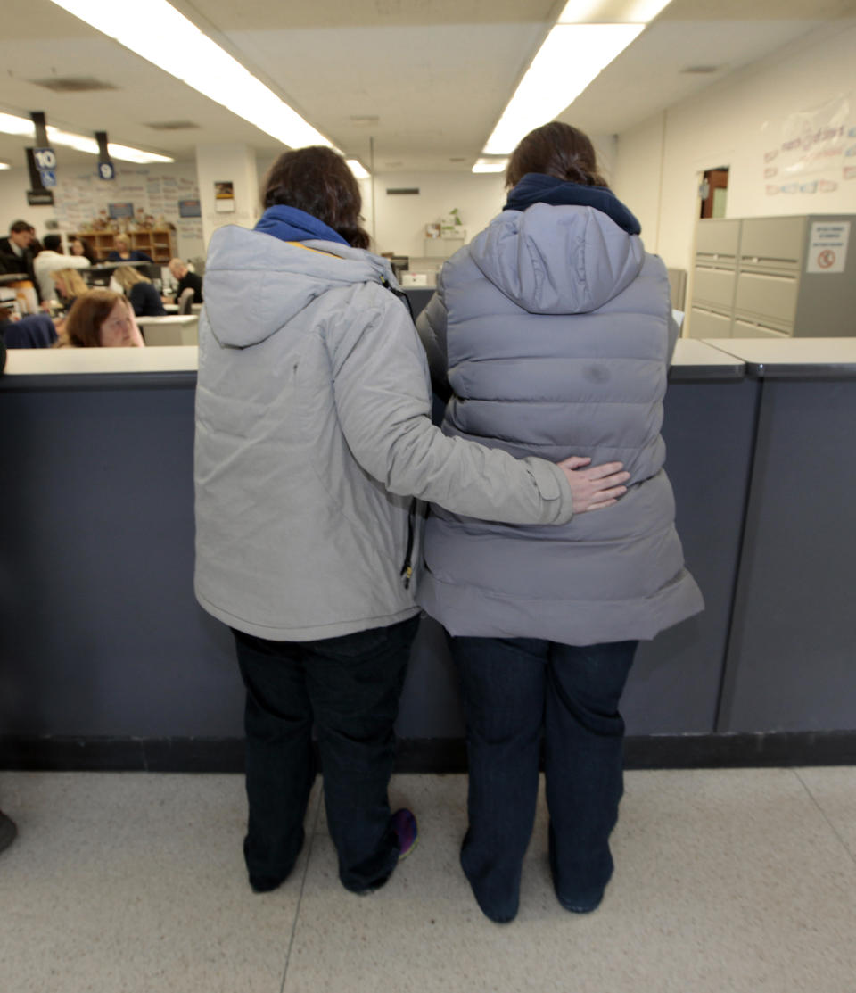 A same sex couple wait for a marriage license at the Oakland County Clerks office in Pontiac, Mich., Saturday, March 22, 2014. A federal judge has struck down Michigan's ban on gay marriage Friday the latest in a series of decisions overturning similar laws across the U.S. Some counties plan to issue marriage licenses to same-sex couples Saturday, less than 24 hours after a judge overturned Michigan's ban on gay marriage. (AP Photo/Paul Sancya)