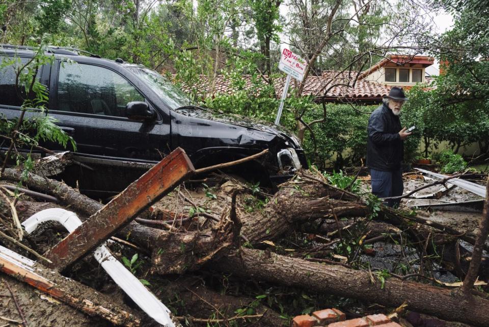 Clarence Brown assesses damage due to a landslide from heavy rainfall on Lockridge Road in Studio City