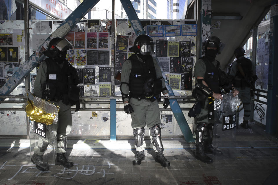 Police officers in riot gear gather on a pedestrian overpass during an anti-government protest in Hong Kong, Saturday, Nov. 2, 2019. Defying a police ban, thousands of black-clad masked protesters are streaming into Hong Kong's central shopping district for another rally demanding autonomy in the Chinese territory as Beijing indicated it could tighten its grip. (AP Photo/Kin Cheung)