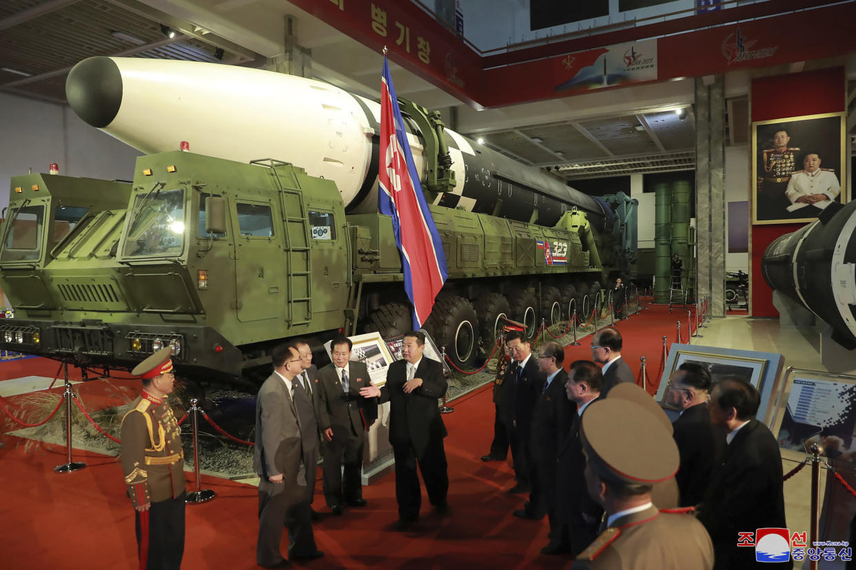 In this photo provided by the North Korean government, North Korean leader Kim Jong Un, center, speaks in front of what the North says an intercontinental ballistic missile displayed at an exhibition of weapons systems in Pyongyang, North Korea, Monday, Oct. 11, 2021. (Korean Central News Agency/Korea News Service via AP)