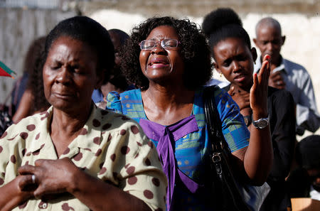 Congregants pray outside during a service after their church was destroyed by Cyclone Idai, in Beira, Mozambique, March 24, 2019. REUTERS/Siphiwe Sibeko