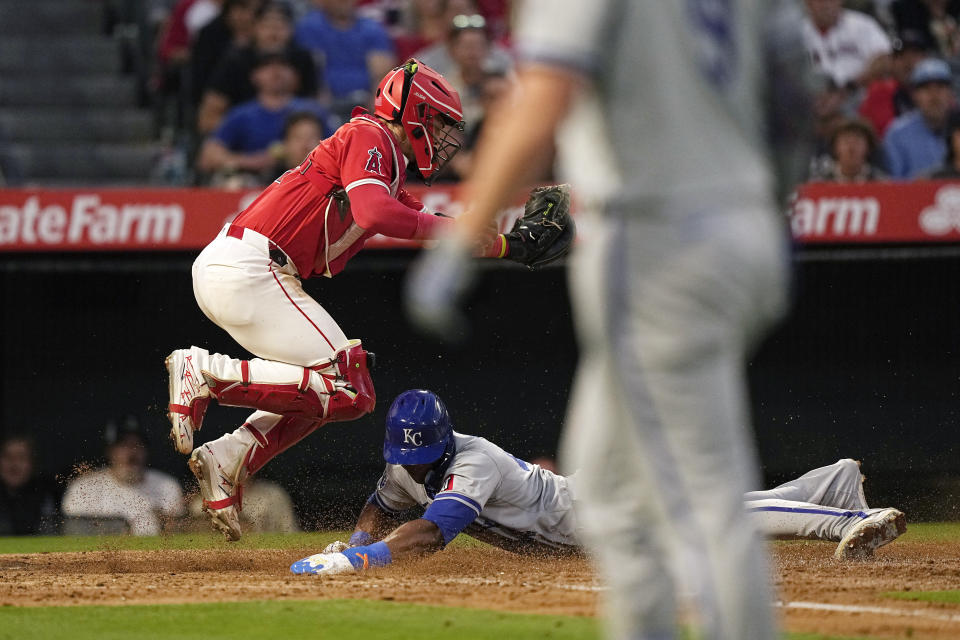 Kansas City Royals' Dairon Blanco, center, scores on a sacrifice fly by Vinnie Pasquantino, right, as Los Angeles Angels catcher Logan O'Hoppe attempts a late tag during the fifth inning of a baseball game Thursday, May 9, 2024, in Anaheim, Calif. (AP Photo/Mark J. Terrill)