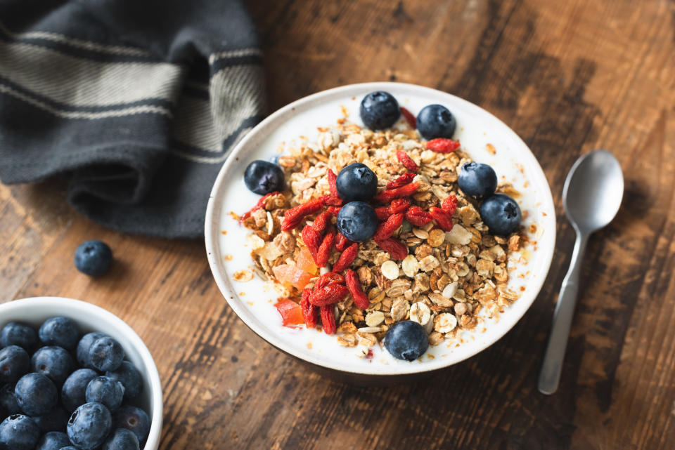 Granola bowl with yogurt, blueberries and goji berries on old wooden table. Healthy vegetarian eating, healthy lifestyle concept