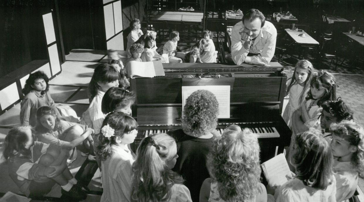 In June 1988, Director Tod Booth of the Alhambra Dinner Theatre leans over the piano as a group of girls hit the high note in the song "It's the Hard Knock Life" from "Annie." More than 120 girls tried out for the title role.