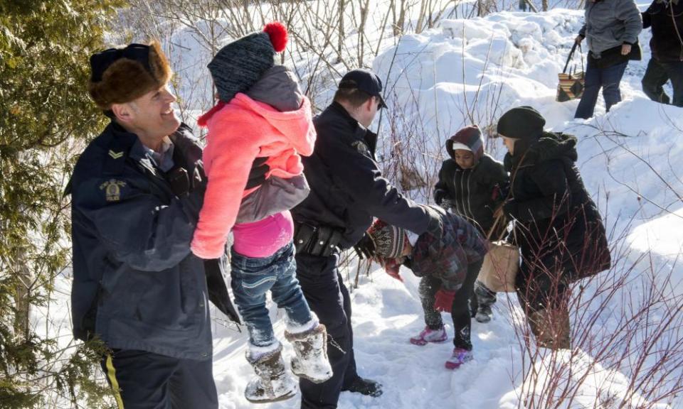 A Somalian family is helped into Canada by Royal Canadian Mounted Police officers in February 2017. During that year, some 2,550 US citizens applied for asylum in Canada.