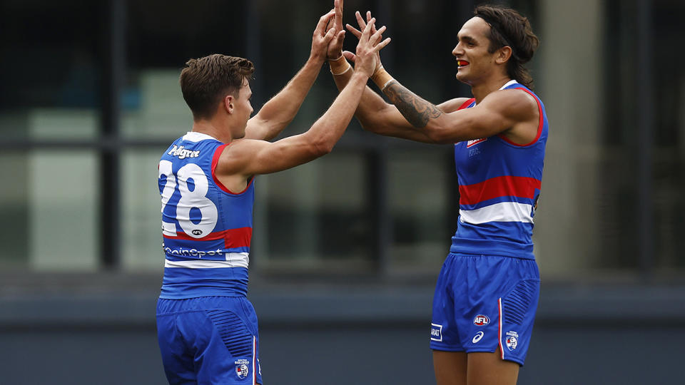 Jamarra Ugle-Hagan, pictured right, high-fives a teammate.