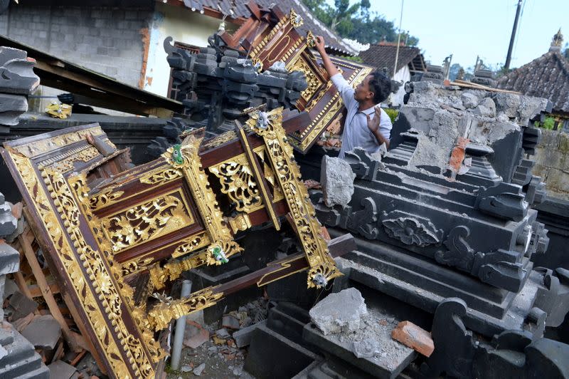 A man is seen among damaged buildings of a temple after a 4.8 magnitude earthquake struck northeast of Bali