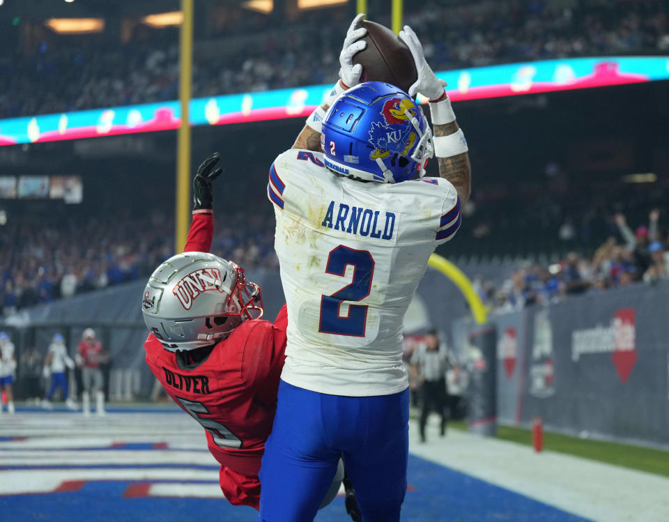 Kansas Jayhawks wide receiver Lawrence Arnold (2) catches a touchdown against UNLV Rebels defensive back Cameron Oliver (5) during the first half of the Guaranteed Rate Bowl on Tuesday in Phoenix at Chase Field.