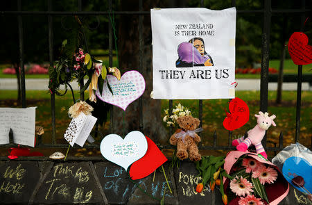 Flowers and signs are seen at a memorial site for victims of the mosque shootings, at the Botanic Gardens in Christchurch, New Zealand, March 18, 2019. REUTERS/Edgar Su