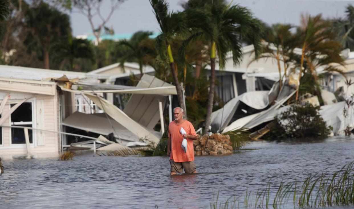 In this file photo, resident Stan Pentz walks out of a Iona neighborhood one day after Hurricane Ian made landfall on Thursday, Sept. 28, 2022. Behind him, homes have been crushed by the storm.