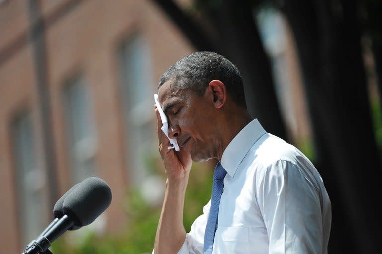 US President Barack Obama wipes his brow as he speaks on climate change on June 25, 2013 at Georgetown University in Washington