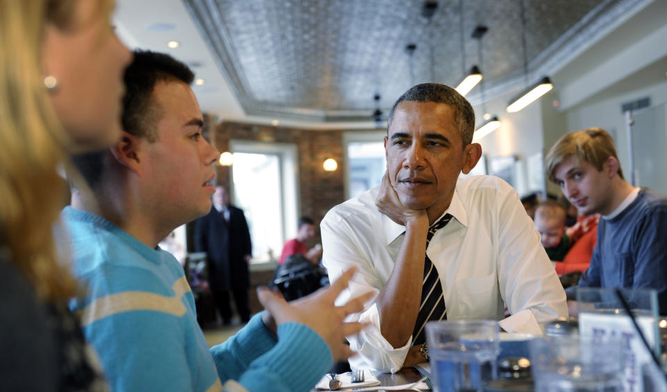 President Barack Obama listens to Andres Cruz, second from left, as he has lunch with five young people at The Coupe restaurant in the Columbia Heights section of Washington, Friday, Jan. 10, 2014. The five are spearheading creative outreach efforts to connect with and help enroll young consumers through the Marketplaces or are interested in getting more involved with these efforts. Seated at the table with Obama at left is Anne Johnson. (AP Photo/Susan Walsh)