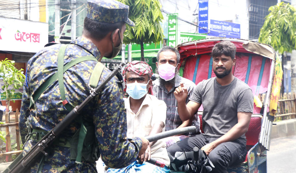 A policeman stops commuters in Rajshahi, 254 kilometers (158 miles) north of the capital, Dhaka, Bangladesh, June 16, 2021. Rajshahi has become one of the latest hotspots for the deadlier delta variant of the coronavirus. Bangladeshi authorities are increasingly becoming worried over the quick spread of coronavirus in about two dozen border districts close to India amid concern that the virus could devastate the crowded nation in coming weeks. (AP Photo/ Kabir Tuhin)