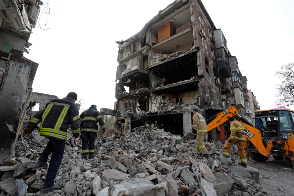 Rescuers work at a residential building damaged during Ukraine-Russia conflict in the southern port city of Mariupol, Ukraine April 19, 2022. 