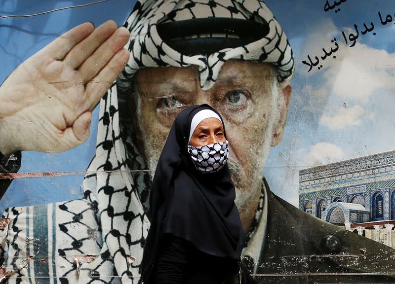 A woman covering her face walks in Shatila Palestinian refugee camp in Beirut suburbs