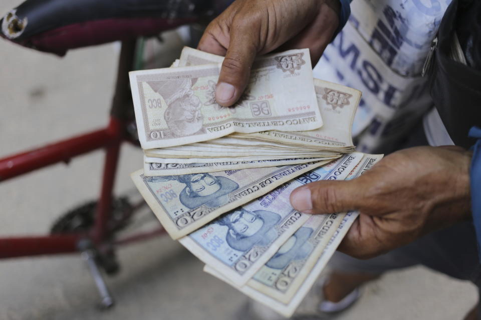 Un vendedor ambulante de helados muestra sus pesos cubanos, en La Habana, Cuba, el 20 de abril de 2024. Cada vez más cubanos tienen que lidiar con la escasez de dinero en efectivo en el país. Convertir esos pesos cubanos a otra moneda supone otro desafío debido a las varias y altamente fluctuantes tasas de intercambio en la isla. (AP Foto/Ariel Ley)