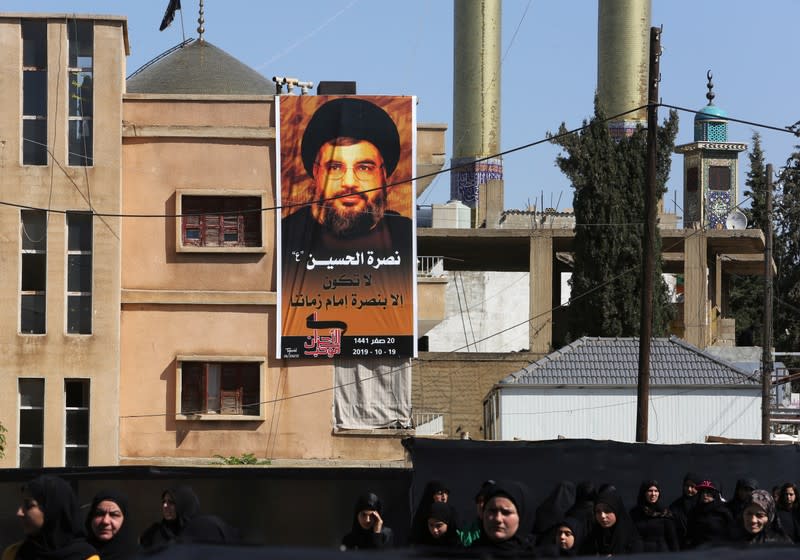 A banner depicting Lebanon's Hezbollah leader Sayyed Hassan Nasrallah is hung as his supporters listen to his televised speech in Baalbeck