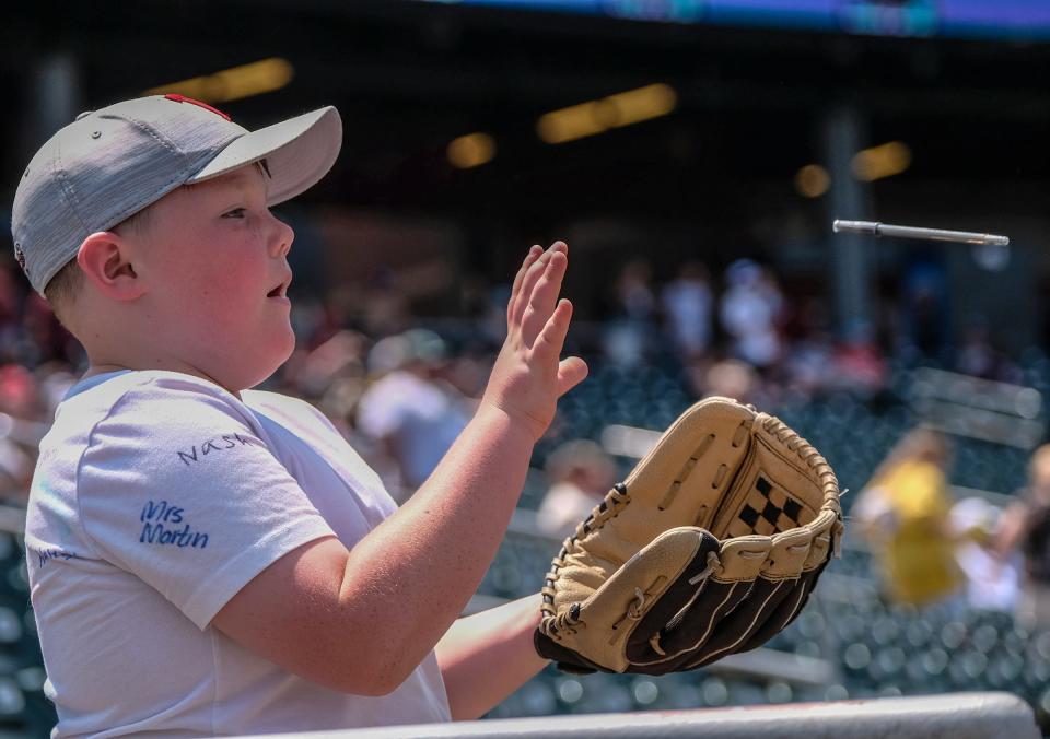 Liam Wheeler, 9, from Ithaca catches his autograph pen tossed back from a Lugnuts player Sunday, June 18, 2023.