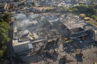 Ukrainian State Emergency Service firefighters work to take away debris at a shopping center burned after a rocket attack in Kremenchuk, Ukraine, Tuesday, June 28, 2022. (AP Photo/Efrem Lukatsky)