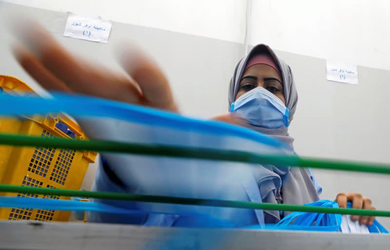 A woman wearing a protective face mask works at a factory that produces sterilised surgical equipment and medical clothings in Egypt