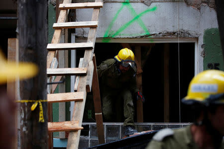 A member of the Israel rescue team searches for survivors in a collapsed building after an earthquake in Mexico City, Mexico September 21, 2017. REUTERS/Carlos Jasso