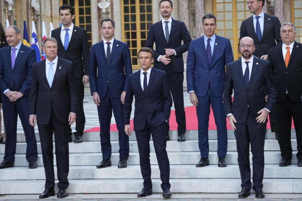 Front row left to right, Romania's President Klaus Werner Ioannis, French President Emmanuel Macron, and European Council President Charles Michel stand with other EU leaders during a group photo at an EU summit at the Chateau de Versailles, in Versailles, west of Paris, Thursday, March 10, 2022. European Union leaders on Thursday will focus on how to help Ukraine in its war with Russia, but the measures discussed are expected to stop short of fulfilling the country's hopes it can soon join the bloc. (AP Photo/Michel Euler)
