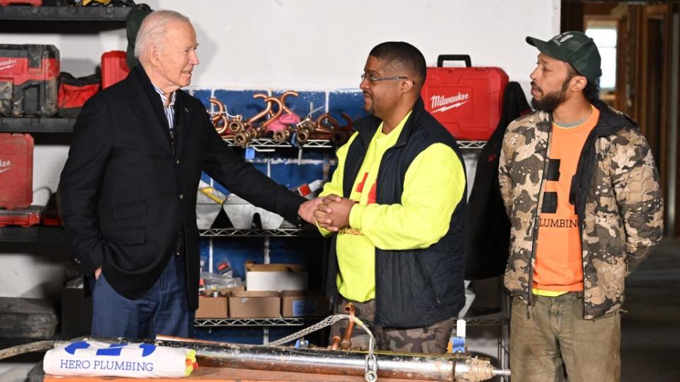 (Left to right) President Joe Biden meets with Rashawn Spivey (CEO of Hero Plumbing Inc.) and one of his workers during a December visit to Milwaukee, Wisconsin. (Photo by Mandel Ngan/AFP via Getty Images)