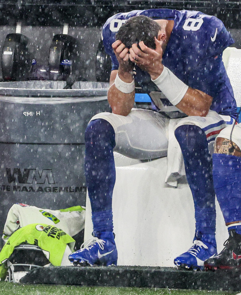 New York Giants quarterback Daniel Jones (8) sits on the bench during a heavy downpour in the fourth quarter of a football game against the Dallas Cowboys on Sunday, Sept. 10, 2023, in East Rutherford, N.J. The Cowboys won, 40-0. (Andrew Mills/NJ Advance Media via AP)