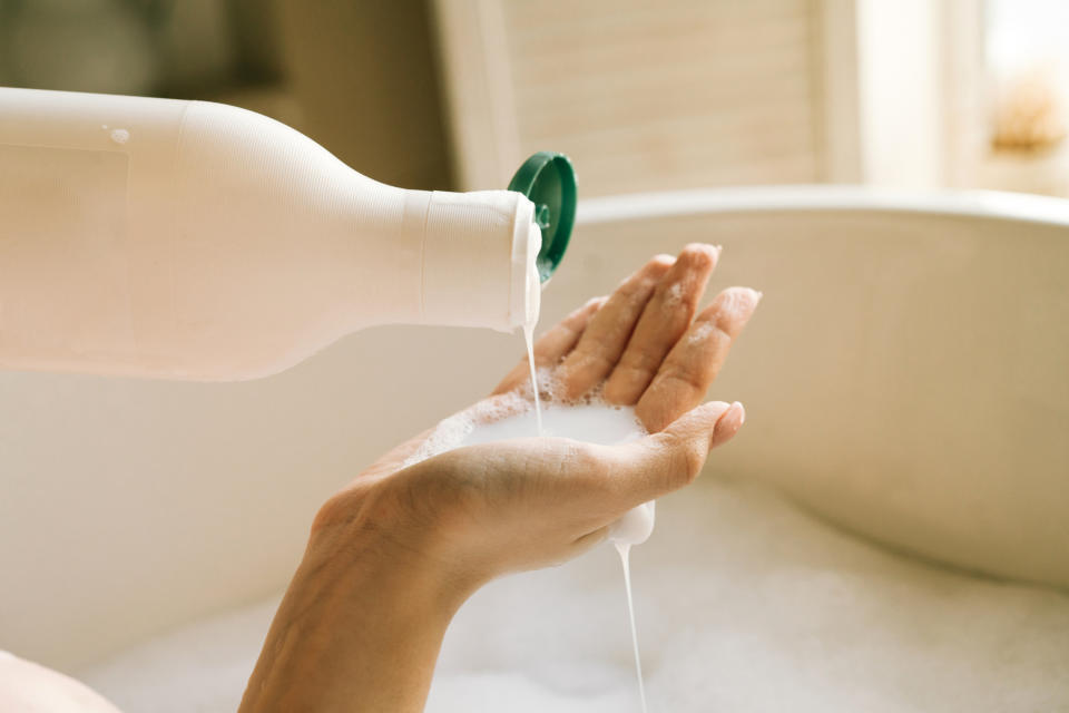 Person pouring liquid soap onto their hand over a sink