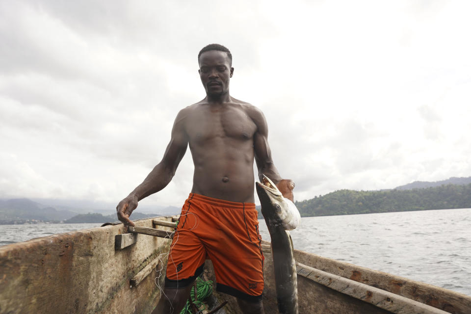 Fisherman Ayafor handles a barracuda he caught in the Atlantic near Limbe, Cameroon, on April 12, 2022. In recent years, Cameroon has emerged as one of several go-to countries for the widely criticized “flags of convenience” system, under which foreign companies can register their ships even though there is no link between the vessel and the nation whose flag it flies. But experts say weak oversight and enforcement of fishing fleets undermines global attempts to sustainably manage fisheries and threatens the livelihoods of millions of people in regions like West Africa. (AP Photo/Grace Ekpu)