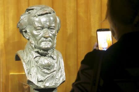 A visitor takes a picture of a bust of German composer Richard Wagner at the Richard Wagner Museum in Bayreuth, Germany, July 24, 2015. REUTERS/Michael Roddy