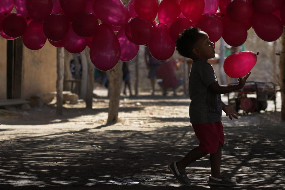 A boy, member of the Kalunga quilombo, a descendant of runaway slaves, prepares the decoration for the coronation of the Emperor of the Holy Spirit, during the culmination of the week-long pilgrimage and celebration for the patron saint "Nossa Senhora da Abadia" or Our Lady of Abadia, in the rural area of Cavalcante in Goias state, Brazil, Sunday, Aug. 14, 2022. (AP Photo/Eraldo Peres)