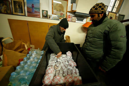 A volunteer distributes cheeseburgers donated by McDonald's to a charity organization which bestowed them to needy people at a walk-in clinic in Rome, Italy January 16, 2017. REUTERS/Tony Gentile