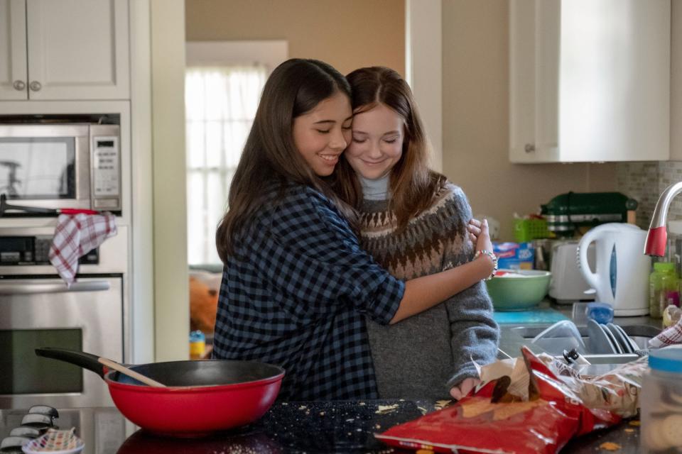 Dawn hugs another member of the baby-sitters club in the kitchen