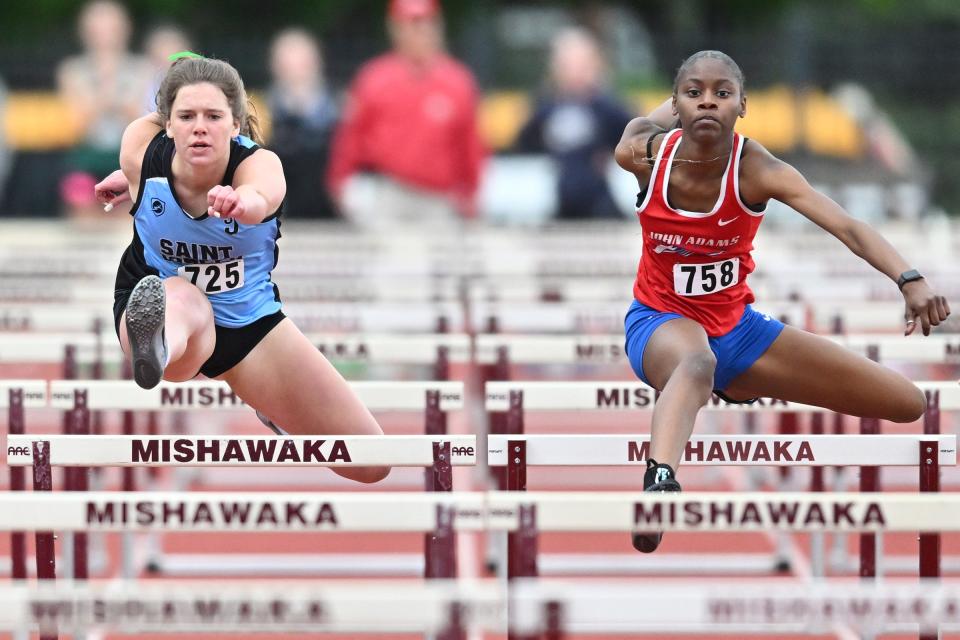 South Bend St. Joseph’s Ella Frick wins over Adams’ Kayla Douglas in the 100 meter hurdles at the Mishawaka Girls IHSAA Sectional track meet Tuesday, May 17, 2022, at Mishawaka High School.