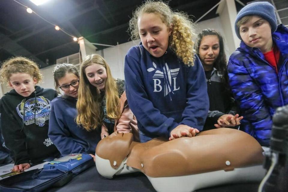 April 18, 2018 - Students from Kennewick’s Bethlehem Lutheran School crowd around classmate Aliyah Thornton, 12, as she learns to do CPR on a mannequin during Safety Connect 2018 at the TRAC center in Pasco. An iPad app shows if the chest compressions are done correctly. The safety fair is a free family event that continues 7 a.m. to 7 p.m. through April 18.