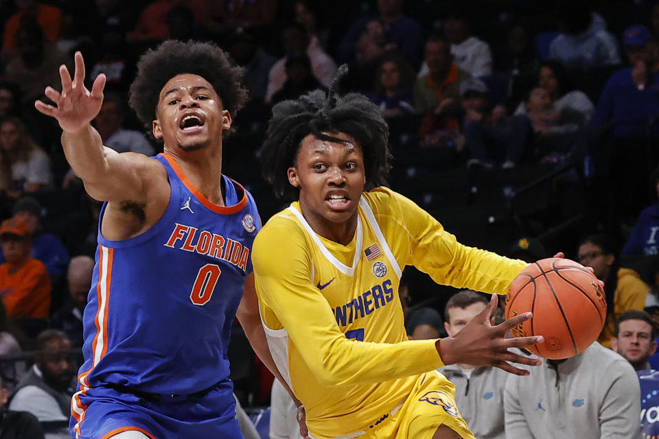 Pittsburgh guard Carlton Carrington (7) drives to the basket against Florida guard Zyon Pullin (0) during the first half of an NCAA college basketball game in the NIT Season Tip-Off at Barclay's center, Wednesday, Nov. 22, 2023, in New York. (AP Photo/Eduardo Munoz Alvarez)