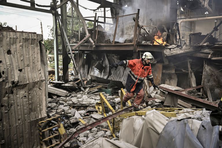 Un bombero participa en la extinción de un incendio en una fábrica de yeso después de un bombardeo en la ciudad de Bakhmut, en la región del Donbass, el 27 de mayo de 2022, en el día 93 de la invasión rusa de Ucrania. (Photo by Aris Messinis / AFP)
