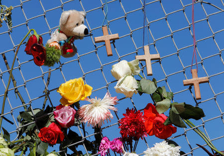 A makeshift memorial featuring crosses, flowers, and a stuffed toy lines a fence near Marjory Stoneman Douglas High School three days after the school shooting in Parkland, Florida, U.S., February 17, 2018. REUTERS/Jonathan Drake