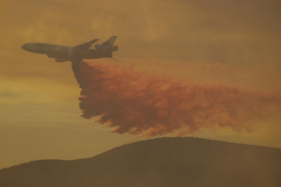 An air tanker drops retardant on a wildfire in Castaic, Calif. on Wednesday, Aug. 31, 2022. (AP Photo/Ringo H.W. Chiu)