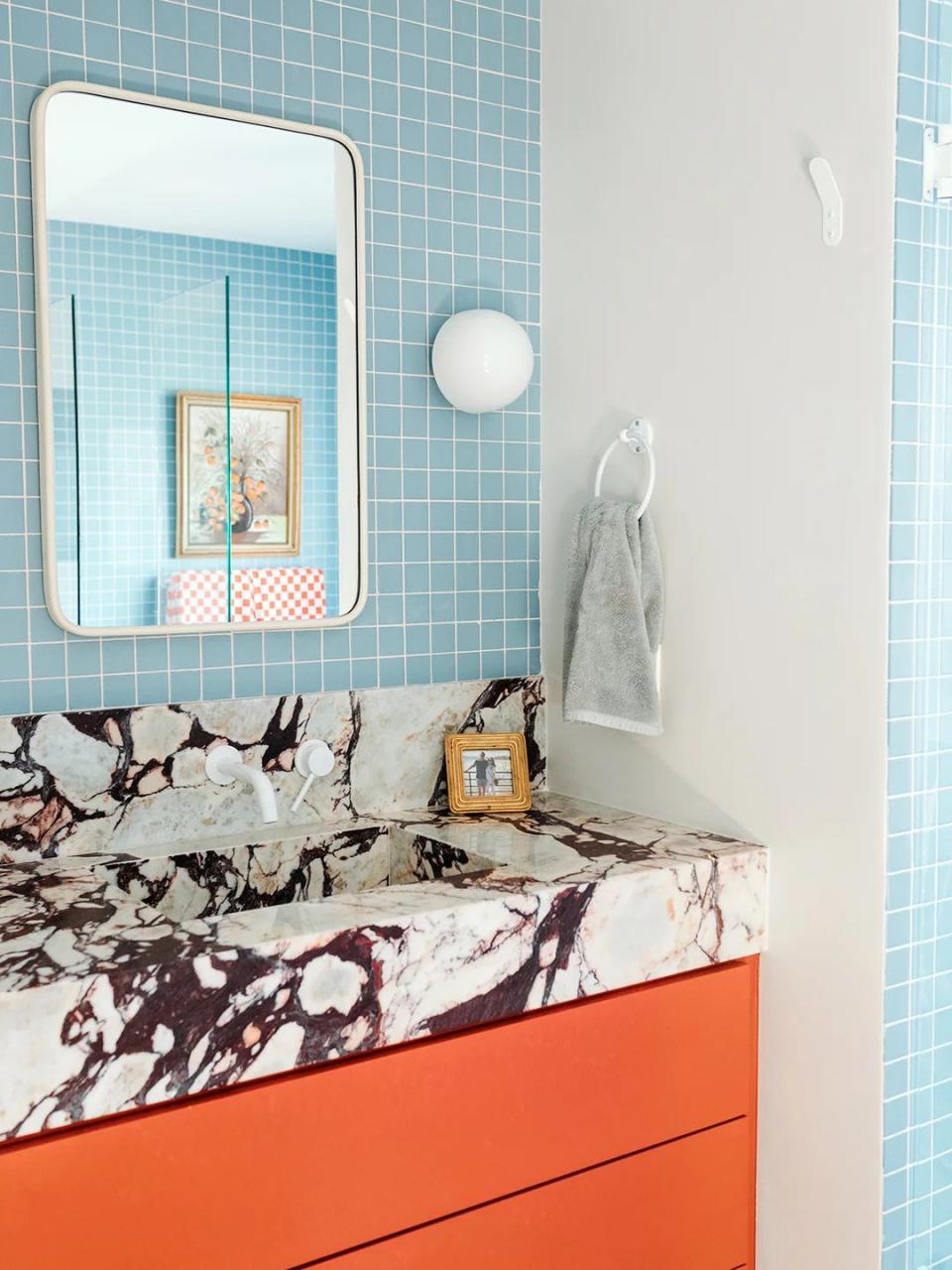 Bathroom with marble vanity and powder blue tiles.