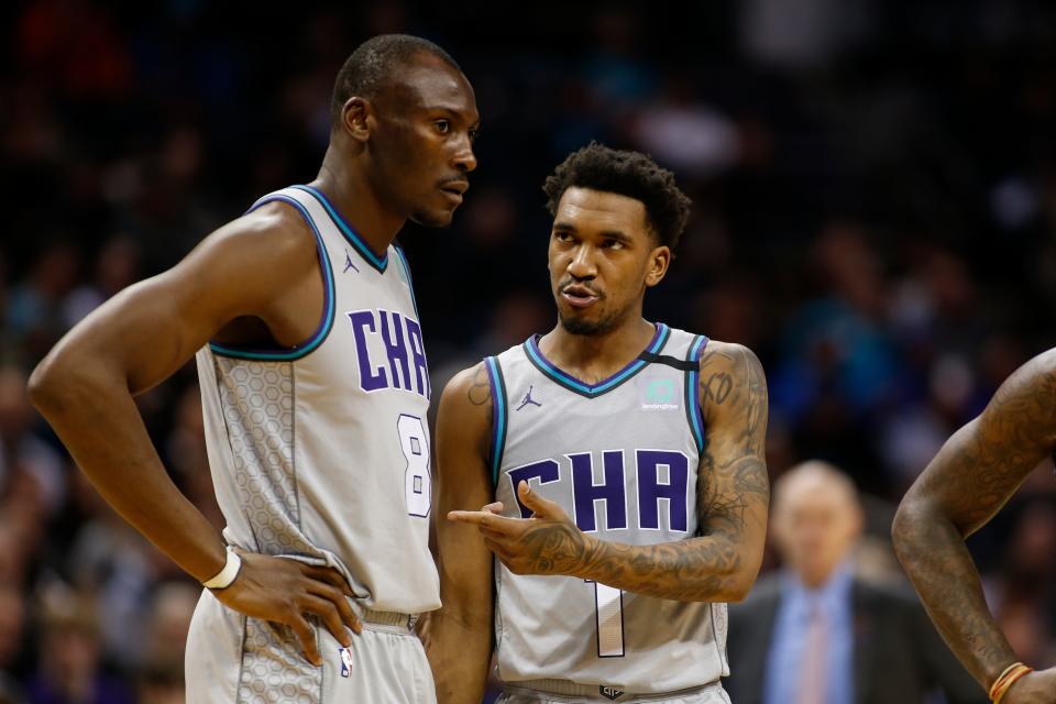 Charlotte Hornets guard Malik Monk, right, talks to center Bismack Biyombo during a break in the action against the Dallas Mavericks in the second half of an NBA basketball game in Charlotte, N.C., Saturday, Feb. 8, 2020. Dallas won 116-100. (AP Photo/Nell Redmond)