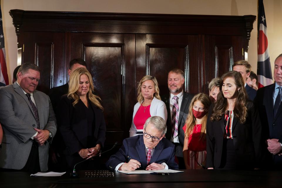 Surrounded by the families of the late Collin Wiant and Stone Foltz, as well as other state lawmakers, Ohio Gov. Mike DeWine on July 6, 2021 signs Ohio's Anti-Hazing Act, also known as "Collin's Law," at the Ohio Statehouse in Columbus. The bill is named after Collin Wiant, who died during a hazing incident in 2018 as a freshman at Ohio University, and makes hazing a felony.