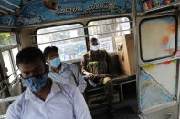 Sri Lankan polling officers sit in a bus as they transport election material to polling centers for Wednesday's parliamentary elections in Colombo, Sri Lanka, Tuesday, Aug. 4, 2020. Sri Lankans are voting in parliamentary elections that are expected to strengthen President Gotabaya Rajapaksa's grip on power. Parts of the party are also calling for a two-thirds majority in Parliament so it can amend the constitution to restore presidential powers curbed by a 2015 constitutional change. (AP Photo/Eranga Jayawardena)