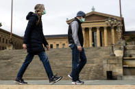 A couple in protective masks during the coronavirus outbreak walk past the Philadelphia Museum of Art in Philadelphia, Friday, April 3, 2020. The museum has temporarily closed due to the COVID-19 pandemic. (AP Photo/Matt Rourke)